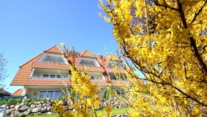 A two-story building with a red-tiled roof and a balcony on the upper floor.