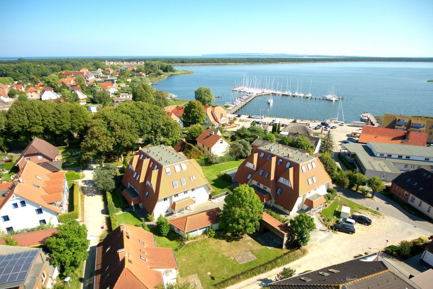 An aerial view of a residential area with houses, a marina, and a dock.