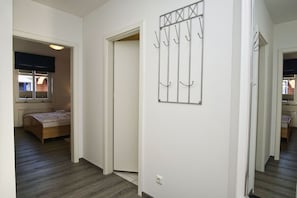 A bedroom with a bed, a window, and a door leading to another room. - 2-room vacation apartment near the harbor with a balcony - Hafenhäuser Breege FeWo 05 - (Breege)