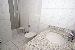 Ein Badezimmer mit Dusche, Toilette und Waschbecken.