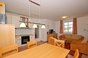 Un espacio habitable compacto con cocina, comedor y sofá.