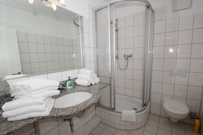 A modern bathroom with a granite countertop, a sink, a mirror, a shower enclosure, and a toilet. - Apartment near the harbor with balcony and sea view - Hafenhäuser Wiek 17 - (Wiek)