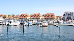 A marina with boats docked, buildings with red roofs, and a clear sky. - Apartment near the harbor with balcony and sea view - Hafenhäuser Wiek FeWo 03 - (Wiek)