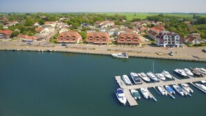 A marina with boats docked, surrounded by residential buildings and greenery. - Apartment near the harbor with balcony and sea view - Hafenhäuser Wiek FeWo 03 - (Wiek)