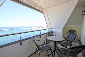 A balcony with a table and chairs, overlooking a marina with boats and a pier. - Apartment near the harbor with balcony and sea view - Hafenhäuser Wiek 06 - (Wiek)
