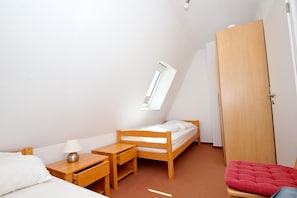 A small, tidy room with a single bed, a desk, a chair, and a wardrobe. - Apartment near the harbor with a balcony and a view of the sea - Hafenhäuser Wiek 06 - (Wiek)