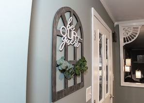 Un pasillo con un marco de puerta decorativo y un letrero que dice 'sean nuestros invitados'.