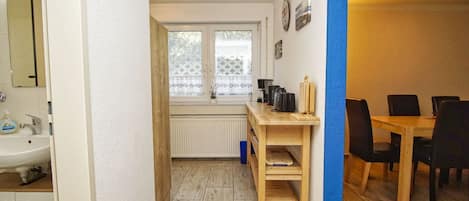 A compact kitchen with a wooden table, a sink, and a window with frosted glass.
