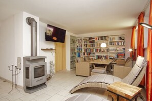 A living room with a fireplace, sofa, table, and bookshelf.