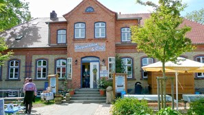 A brick building with a sign reading "Rügenladen & Cafe". - Close to the famous cape, beautiful sandy beach - Ferienresidenz Kap Arkona FeWo 06 - (Putgarten)
