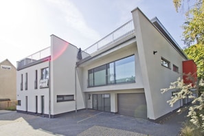 Een modern gebouw met twee verdiepingen, grote ramen en een plat dak.
