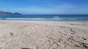 A sandy beach with footprints and a clear blue sky. - House in Alcudia Aran Berna with swimming pool (Alcúdia)