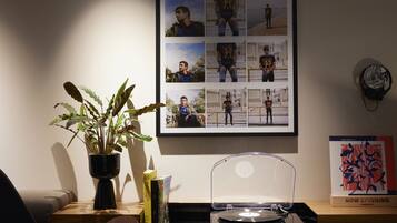 Een moderne kantoorruimte met een houten bureau, een potplant, een lijst met foto's en een platenspeler.