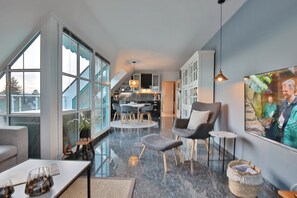 Un interior moderno con comedor, cocina y ventanas amplias.