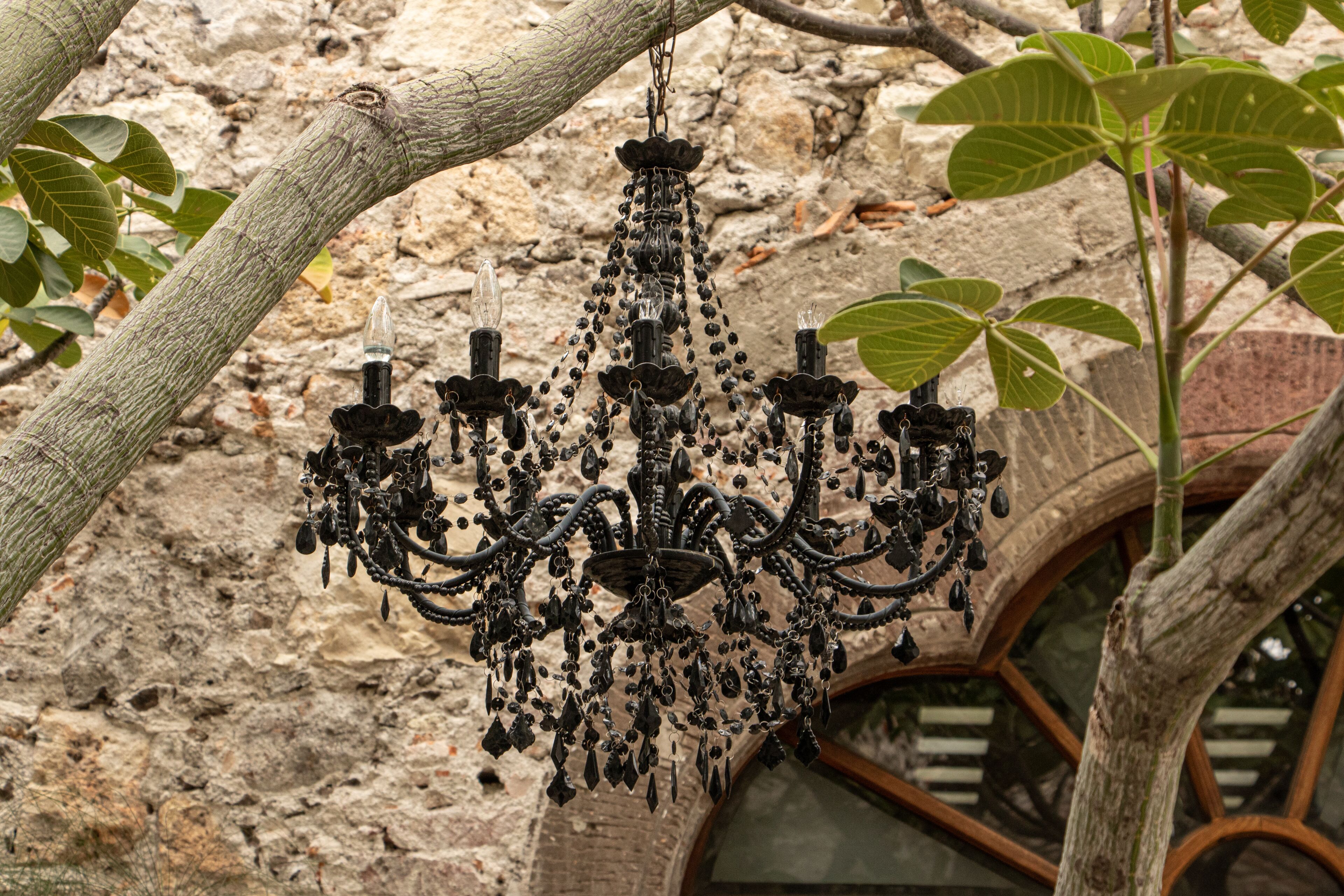 Un candelabro colgado de una rama de árbol en un edificio rústico de piedra.