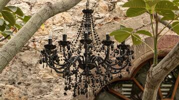 Un candelabro colgado de una rama de árbol en un edificio rústico de piedra.