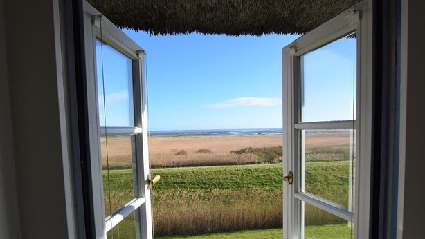 An open door with a view of a grassy field and a clear sky. - Söl'ring Hüs SO/19 - Söl'ring Hüs (Sylt)