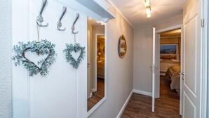 A hallway with a white door, a mirror, and heart-shaped wreaths. - Söl`ring Hüs "Rantumer Perle" App. SO/01 - Söl'ring Hüs (Sylt)
