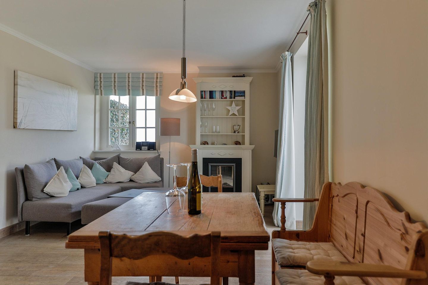 Ein gemütliches Wohnzimmer mit einer Couch, einem Holzesstisch und einem Kamin.