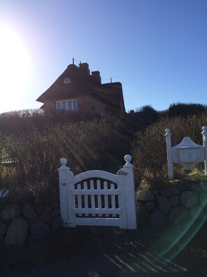 A house with a sloped roof, a chimney, and a white gate in front. - Hellas Hüs - Hellas Hüs ST/48 (Sylt)