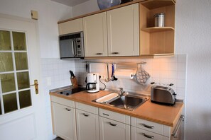 Eine kleine Küche mit Mikrowelle, Toaster und Kaffeemaschine.