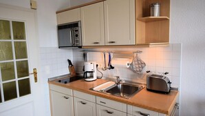 A compact kitchen with a microwave, toaster, and coffee maker. - House Wattblick App. 02 - Wattblick (Sylt)