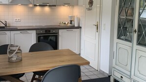 Eine moderne Küche mit weißen Schränken, einem Holzespeisetisch und einem eingebauten Backofen.