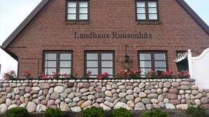 Ein Backsteinhaus mit der Aufschrift "Landhaus Ruusenshuis" an der Fassade.