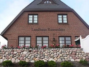 A brick building with the name "Landhaus Ruusenshuis" on the facade. - Landhaus Ruusenhüs App. Ruu 05 - Landhaus Ruusenhüs (Sylt)