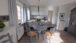 A modern kitchen with a dining table, chairs, and a built-in island.