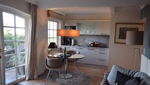 A modern kitchen with a dining area, large windows, and a cozy living space.