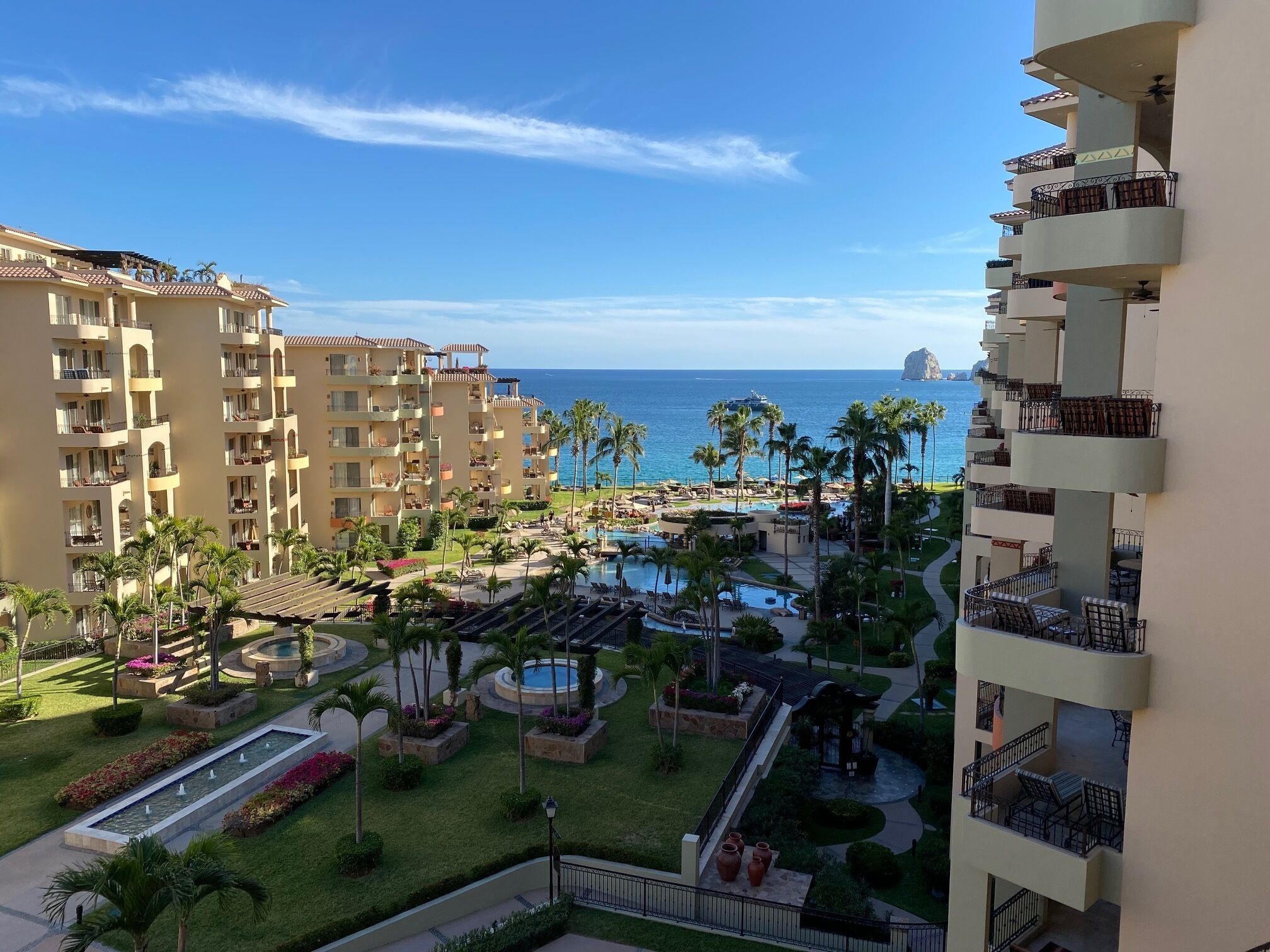 Un resort con edificios de varios pisos, una piscina y vista al océano.