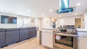 Una cocina moderna con horno empotrado, estufa de acero inoxidable y un amplio ventanal.