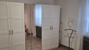 A room with a wardrobe, a radiator, and a window with curtains. - house Bismarckstr. 40 apartments 40 - 3 room apartment with a beautiful terrace. (Sylt)