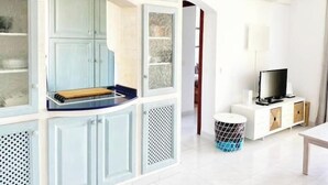 A modern living room with a TV, a small table, and a trash bin. - Beach house 2 Palmeras with pool in Port Pollensa (Port de Pollença)