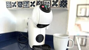 A white coffee maker with a digital display and a coffee pod holder on a blue countertop. - Beach house 2 Palmeras with pool in Port Pollensa (Port de Pollença)