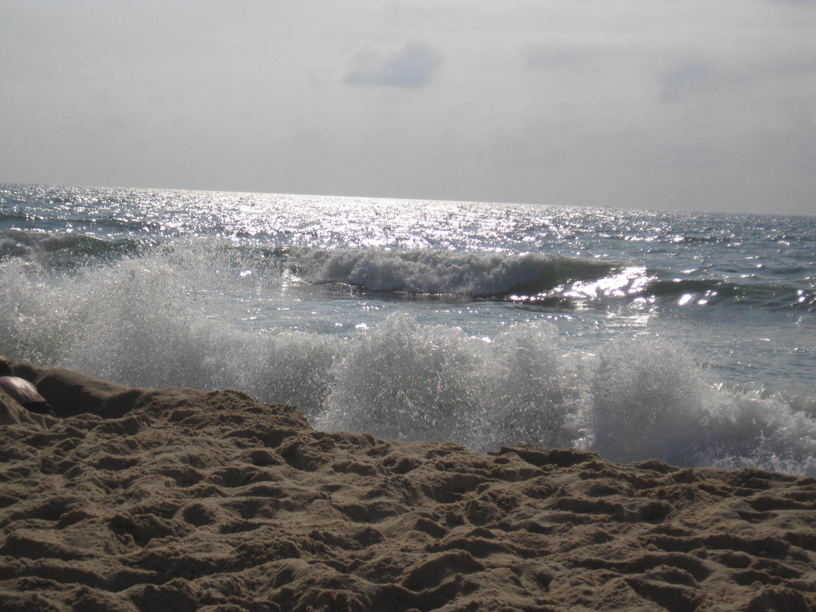 Ein Strand mit brechenden Wellen.