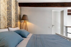 A bedroom with a bed, a lamp, and a door. - Cozy Studios on Freedom Square (Tbilisi)
