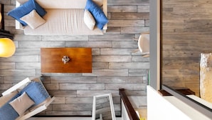 A modern living room with a sofa, a coffee table, and a wooden floor. - Cozy Studios on Freedom Square (Tbilisi)