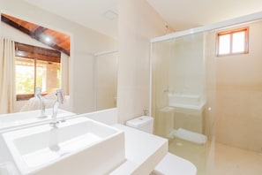 A modern bathroom with a large white sink, a glass-enclosed shower, and a toilet. - GB51 Excelente Casa 4 Suítes Vista Mar (Camaçari)