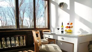 A dining area with a table and chairs, a bottle of wine, and a fruit display. - Spanish steps luxury loft apartment (Roma)