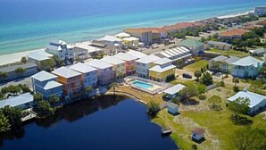 Luchtbeeld van een kustgebied met woningen, een zwembad en een waterpartij.