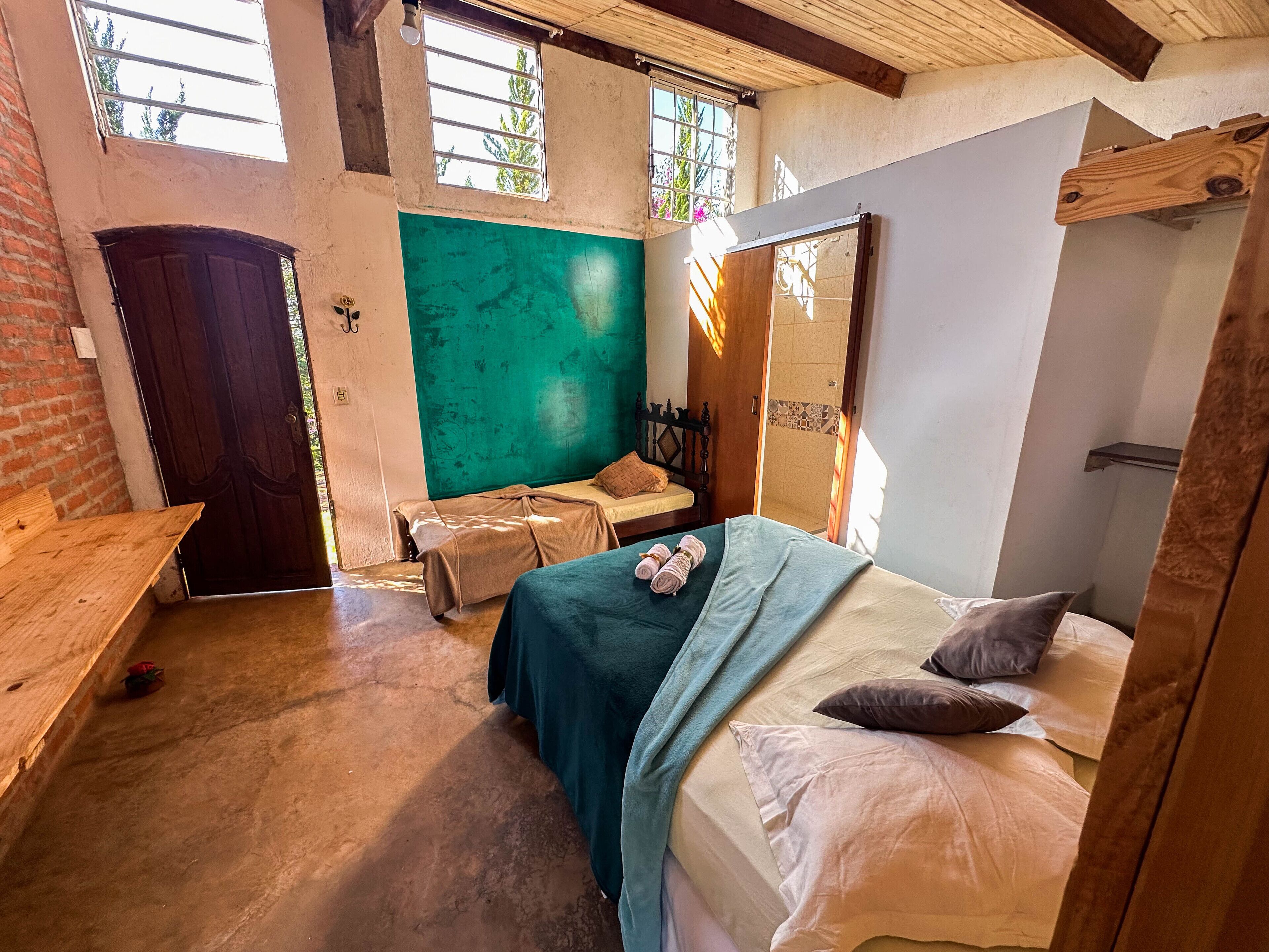 A room with a bed, a bench, and a window.
