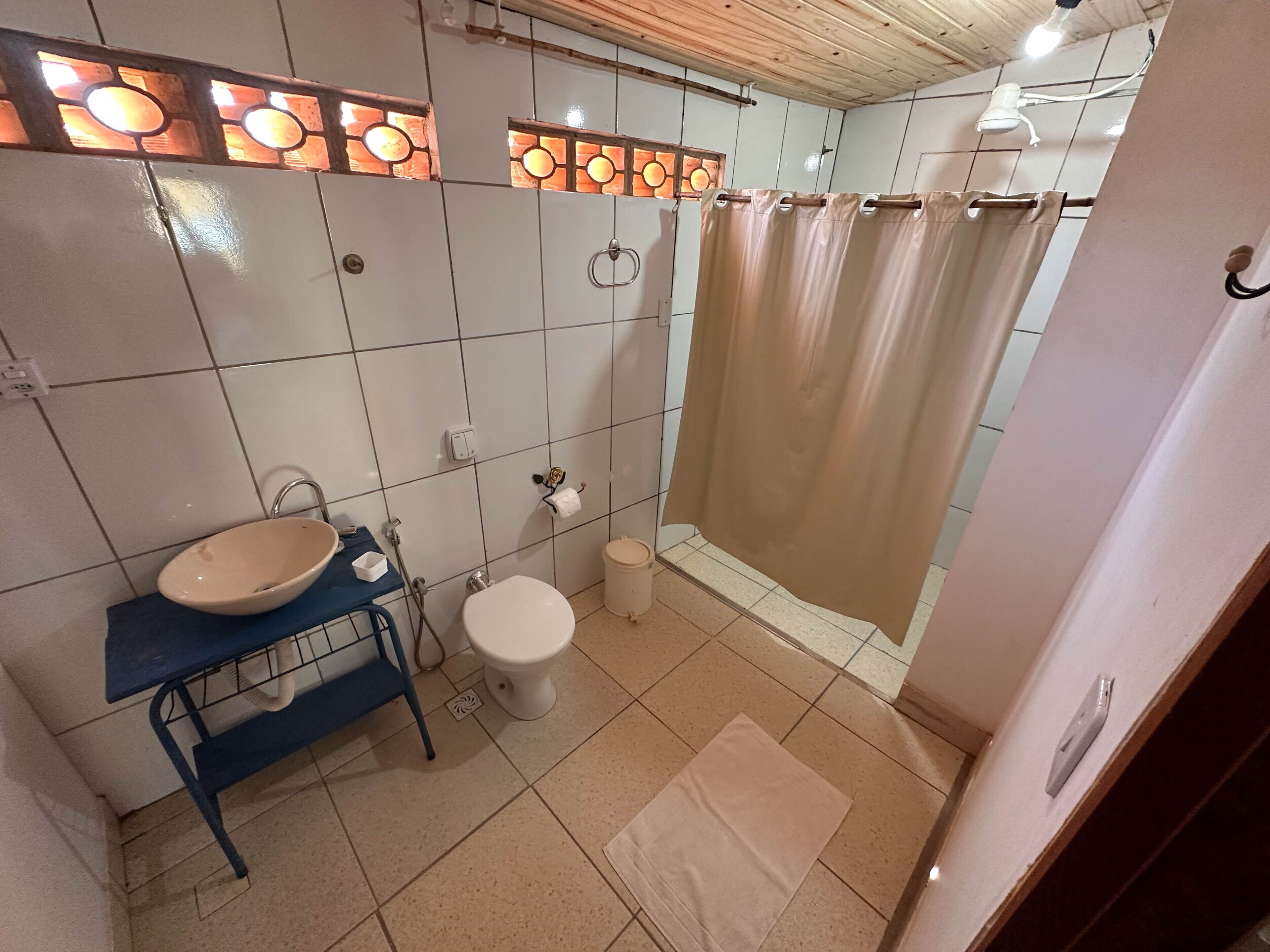 Une salle de bain équipée d’un lavabo, de toilettes et d’un rideau de douche.
