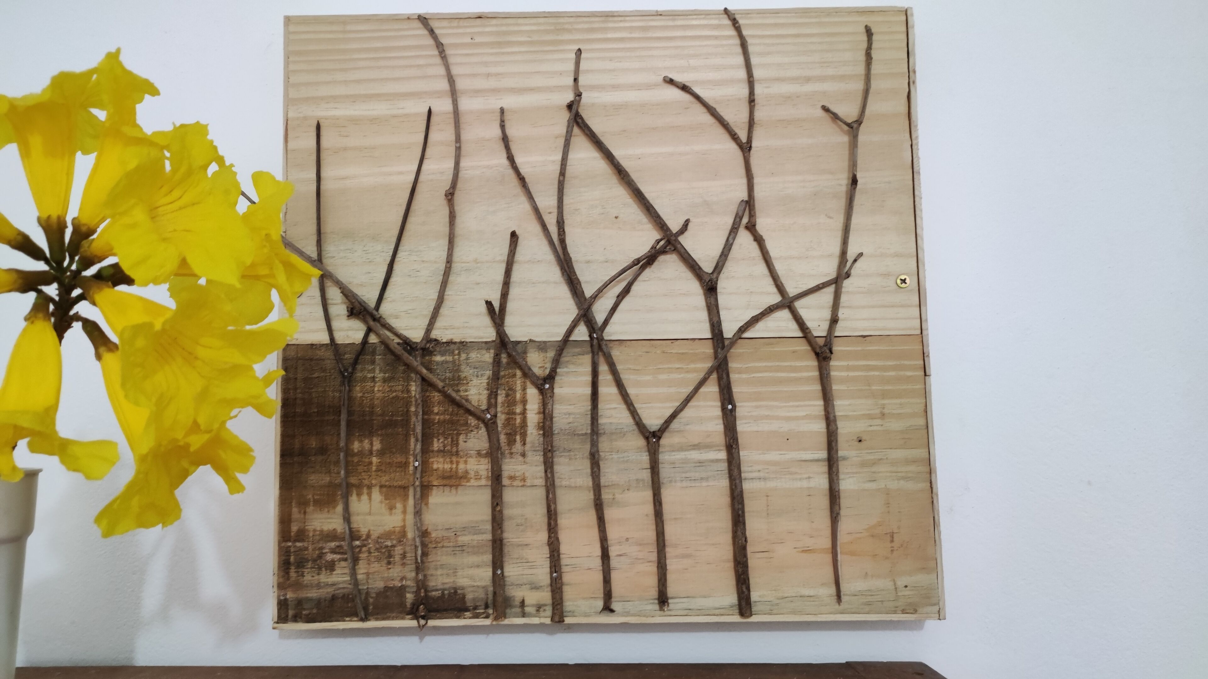 Una obra de arte en la pared que muestra ramas desnudas de un árbol.