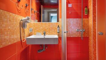 A modern bathroom with a curved shower enclosure, a built-in sink, and a mirror.