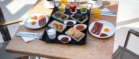 A breakfast tray with various foods and drinks on a wooden table.