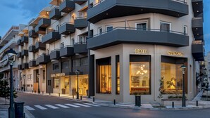 A modern hotel with multiple balconies and a well-lit facade.