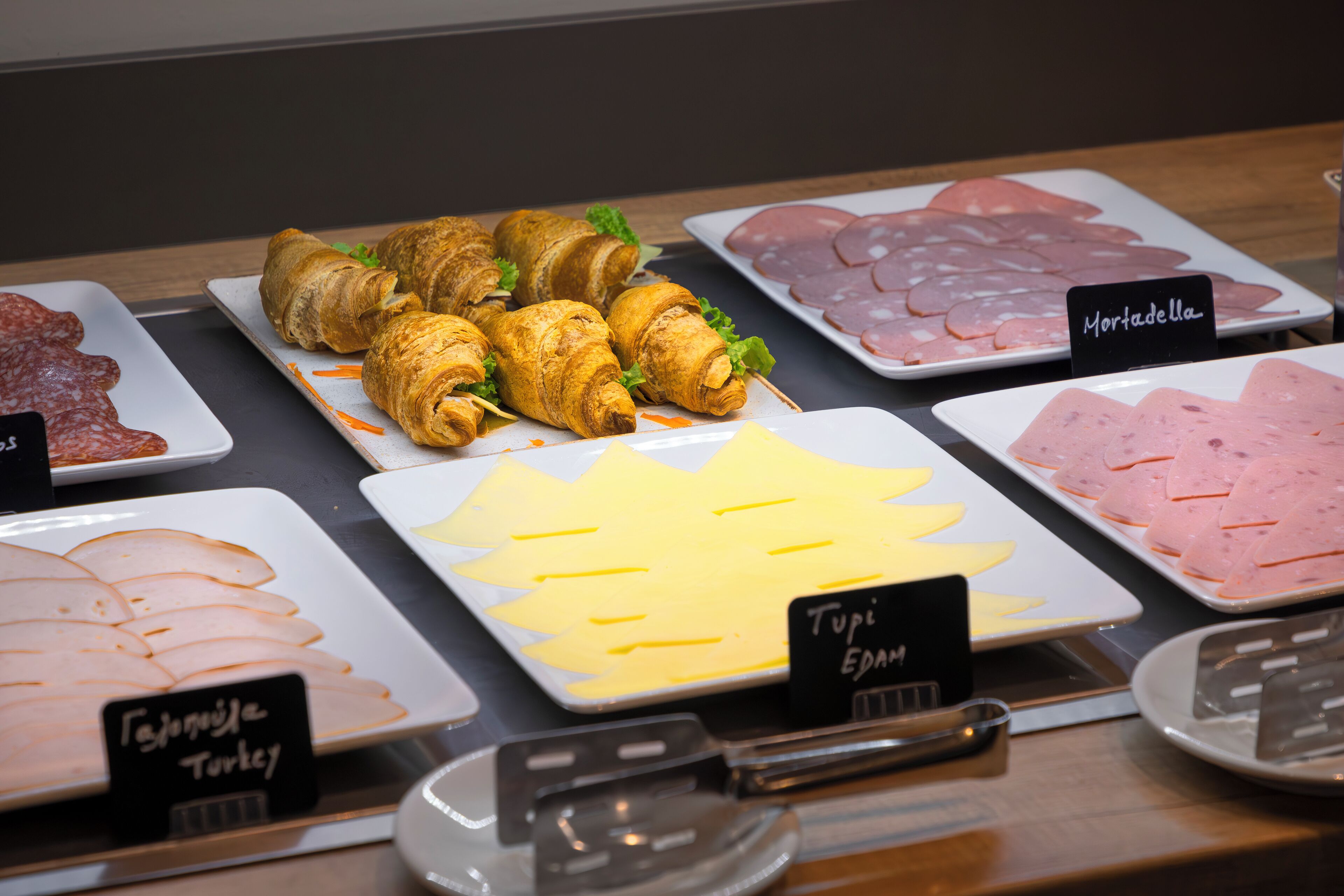 Variedad de alimentos a la vista, como pavo, jamón y queso en rodajas.