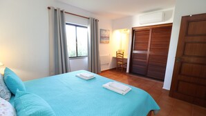 A bedroom with a bed, a chair, a wardrobe, and a window. - 2 Bedroom Apartment with Swimming pool at São Rafael Beach - Albufeira (Albufeira)